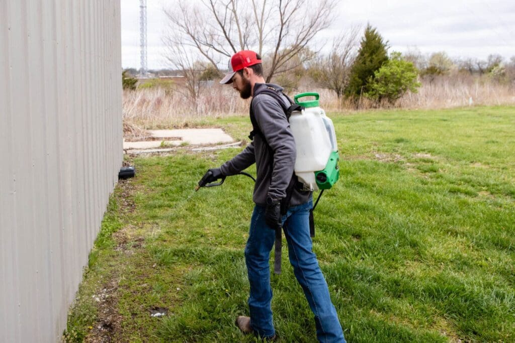 Professional pest control technician treating home in Kansas City